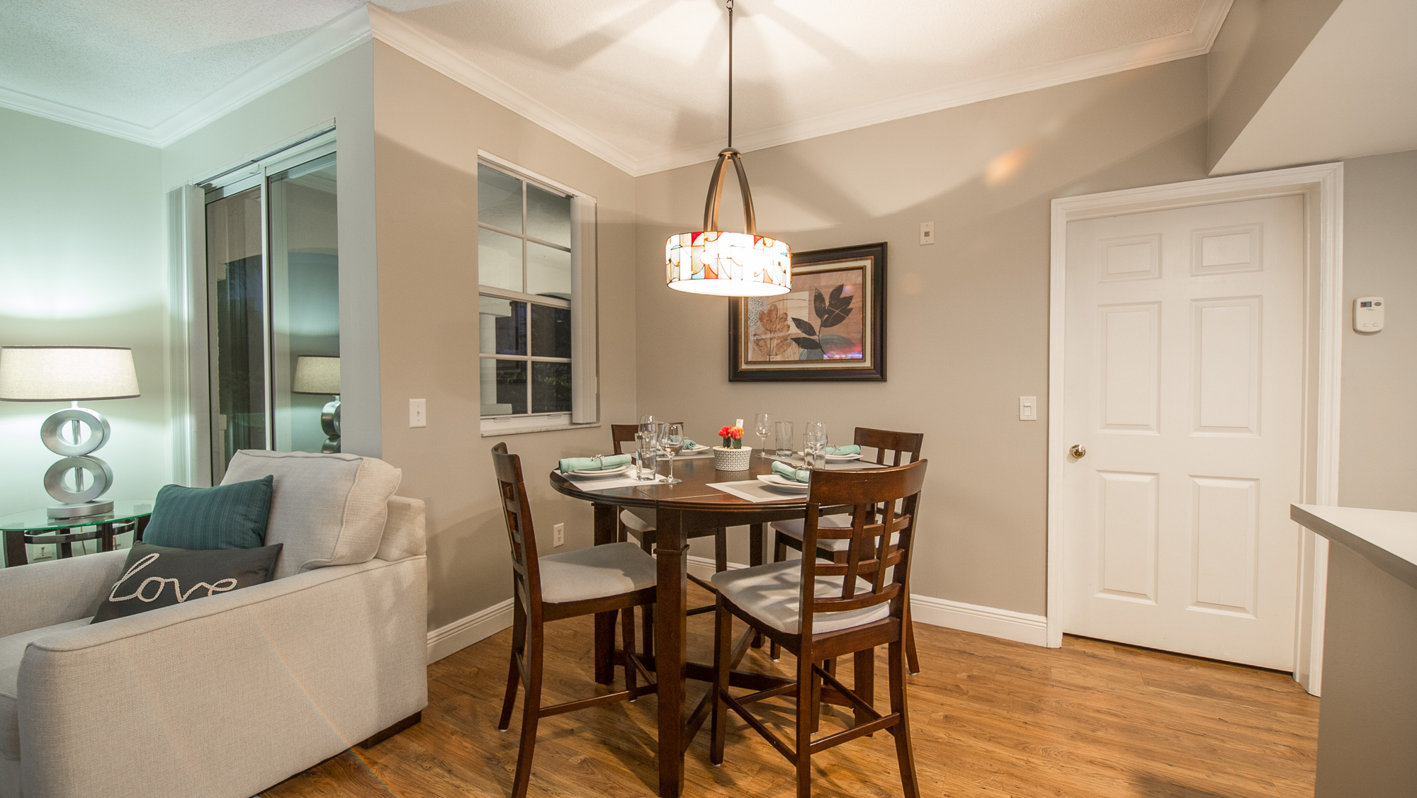 View of the dining table and the entrance to the balcony in the living room at Village By The Bay, Aventura...