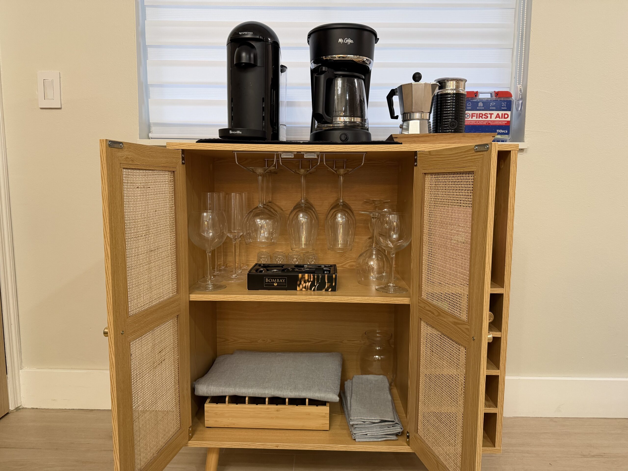 Bar area with stools, glassware display, and stocked shelves in the two-bedroom apartment