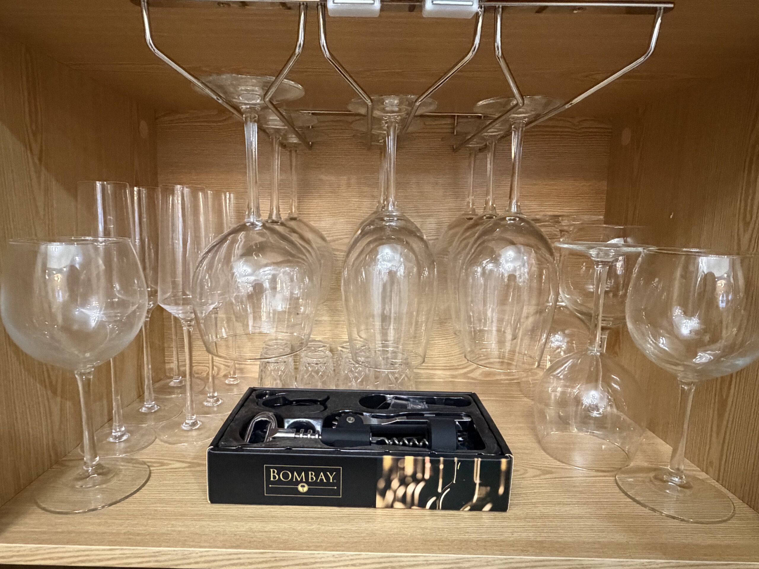 Bar with wine glasses, decanters, and bottle storage in the two-bedroom apartment