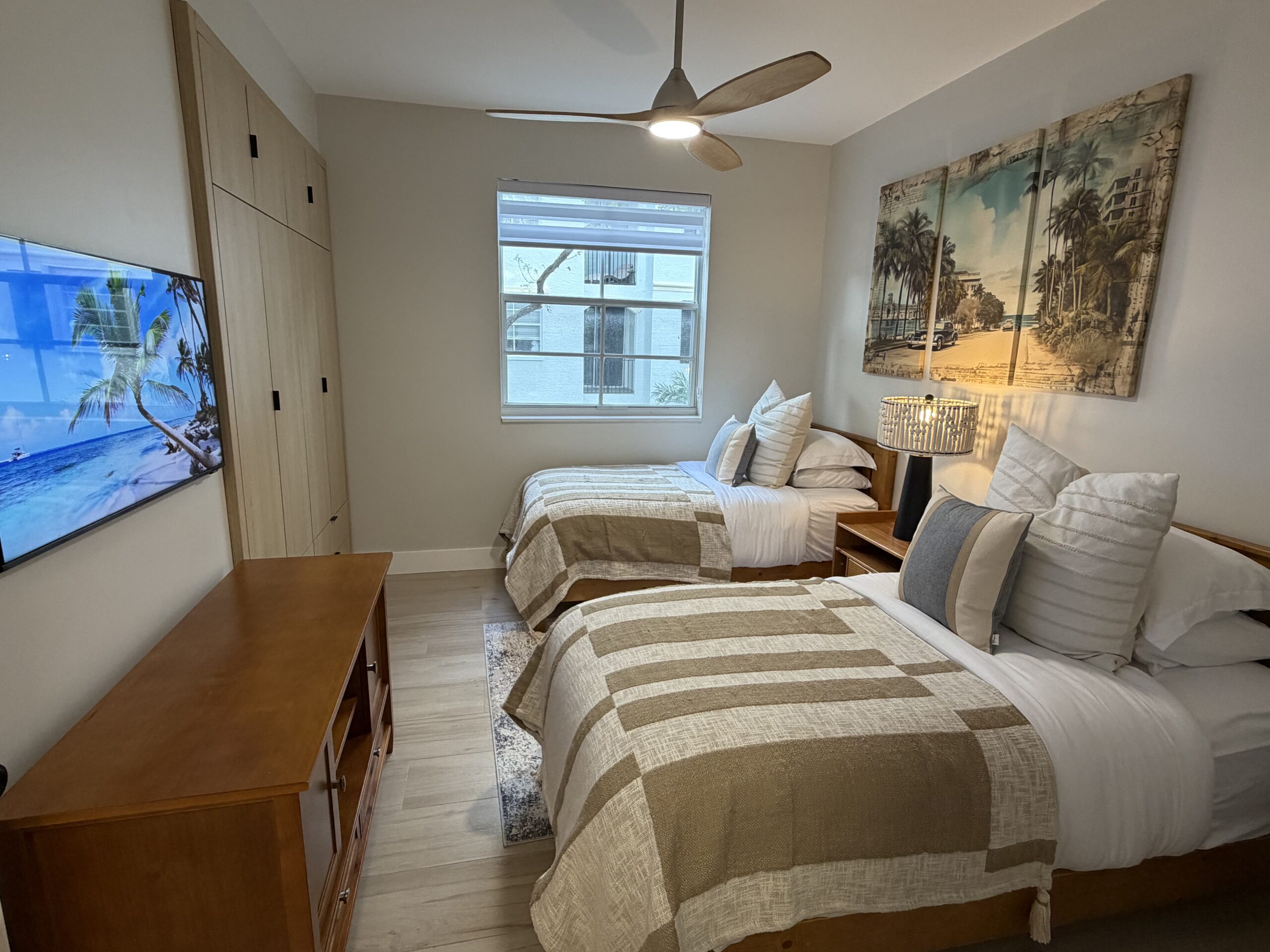 Second bedroom with twin beds, modern decor, and natural light in the Aventura two-bedroom apartment