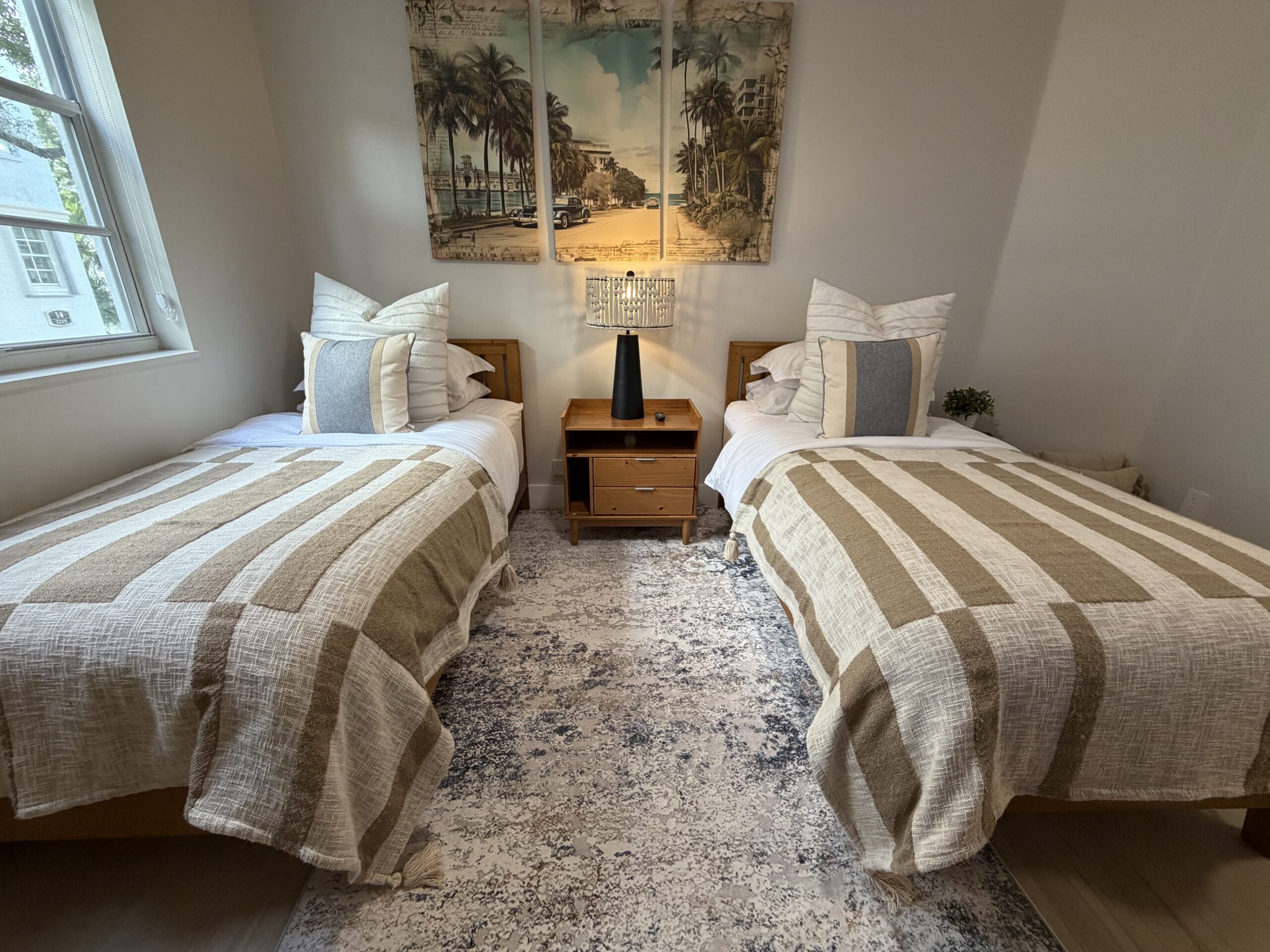 Second bedroom showing twin bed setup, wall art, and clean modern furnishings