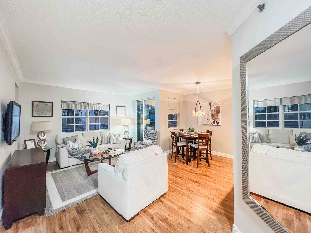 Dining area with seating for four, a large mirror, and hardwood floors