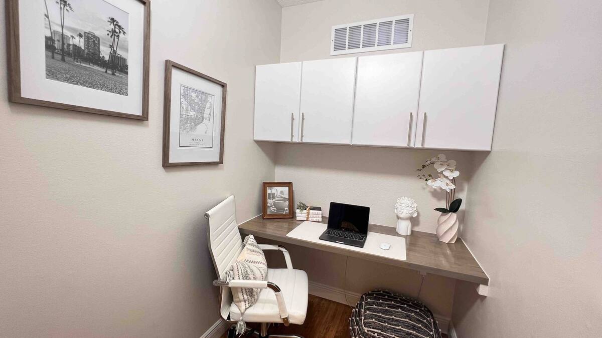 Dedicated workspace with an ergonomic chair, desk, and wall cabinets for remote work